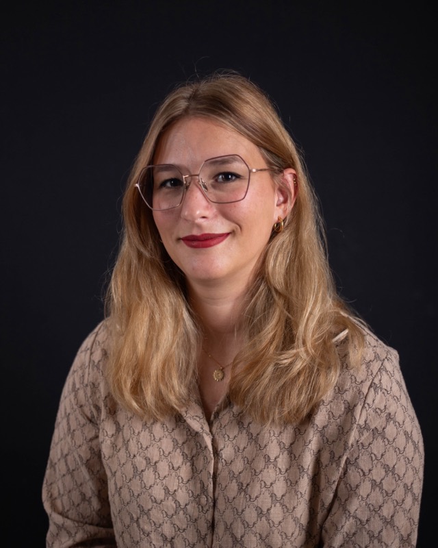 Laurine De Campos, sourire calme, regard vers l'objectif, sur fond sombre